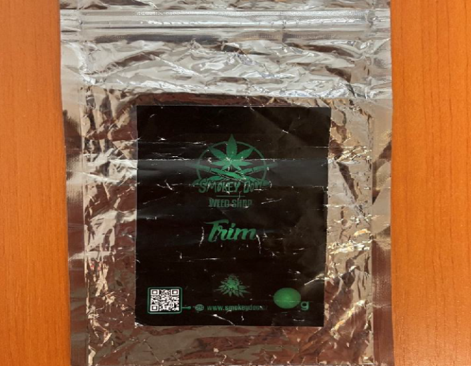 Bylinný výrobek určený ke kouřeníPlastový sáček se sušinou konopí s nápisem „SMOKEY DOO WEED SHOP Trim“